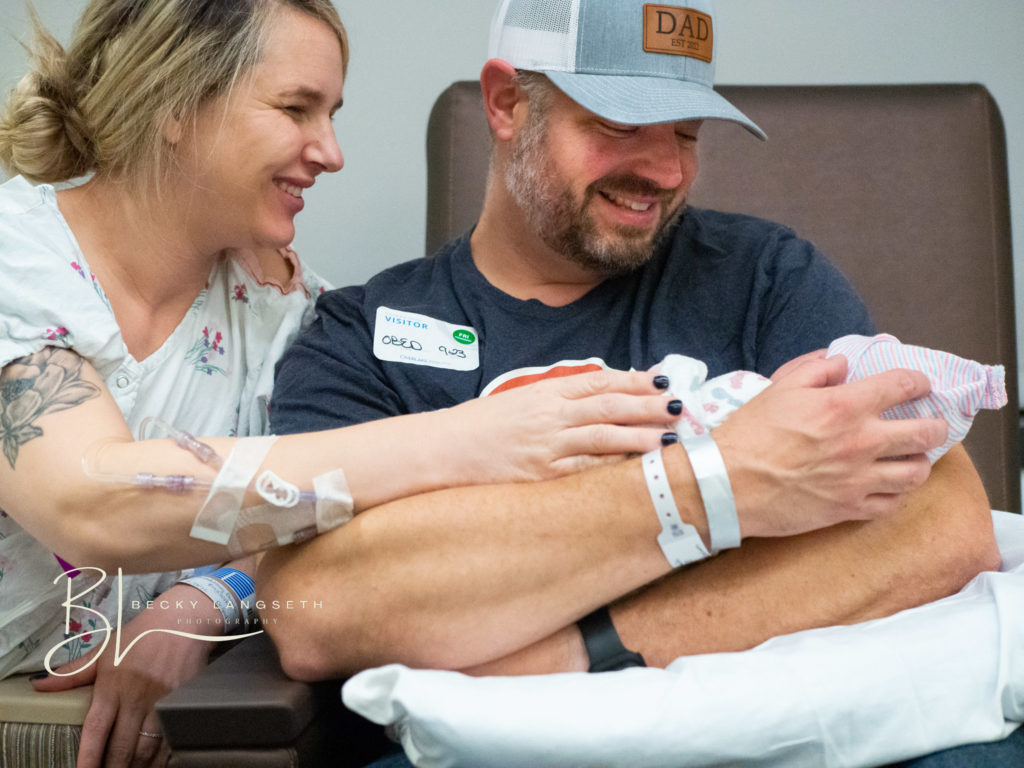 A new dad holds his recently born baby for the first time as his wife sits next to him at Overlake Medical Center in Bellevue, Washington. 