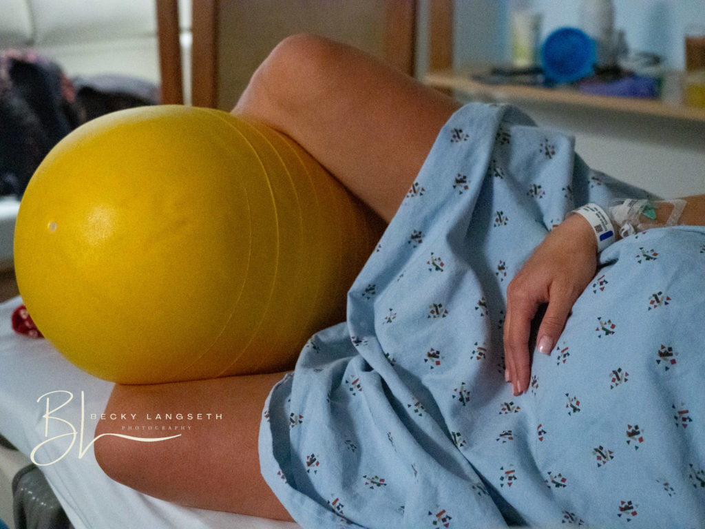 a woman is laboring on a hospital bed at Evergreen Hospital in Kirkland, WA. Image represents how there are misconceptions about birth photography, but it actually can be very beautiful.