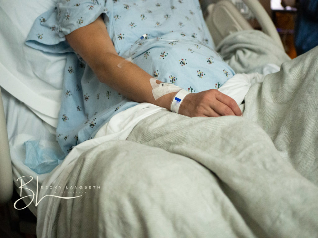 A woman lays in a hospital bed going through contractions before she is about to give birth at the maternity center at Evergreen Hospital in Kirkland, Wa. This image is an example of misconceptions about birth photography and how it can be really beautiful rather than gory.