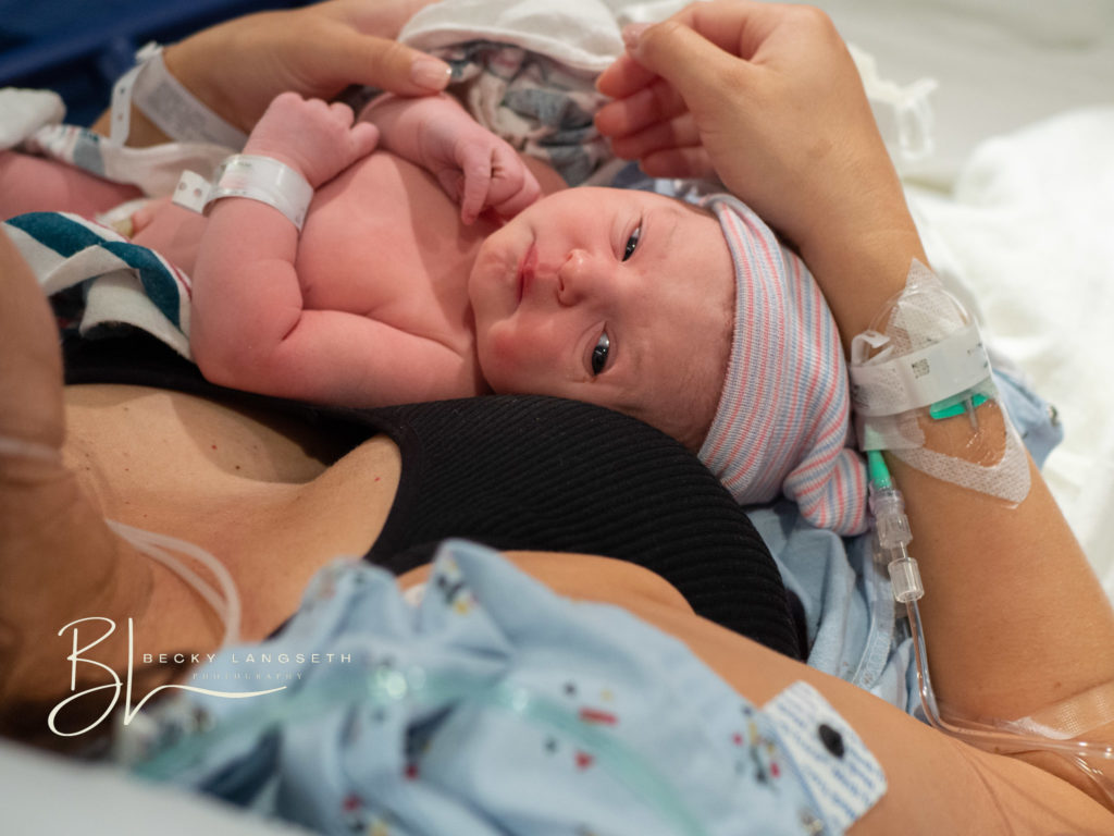 a mother is holding her new baby for the first time after a c-section birth at Evergreen Hospital in Kirkland, WA. The image shows the beauty in birth, by seattle birth photographer, Becky Langseth.