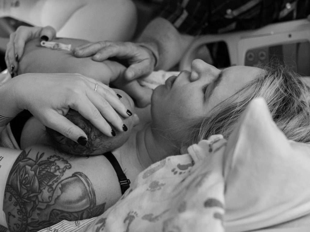 A mother holds her newborn for the first time after just giving birth at Overlake Childbirth Center in Bellevue, WA, captured by Seattle birth photographer, Becky Langseth.