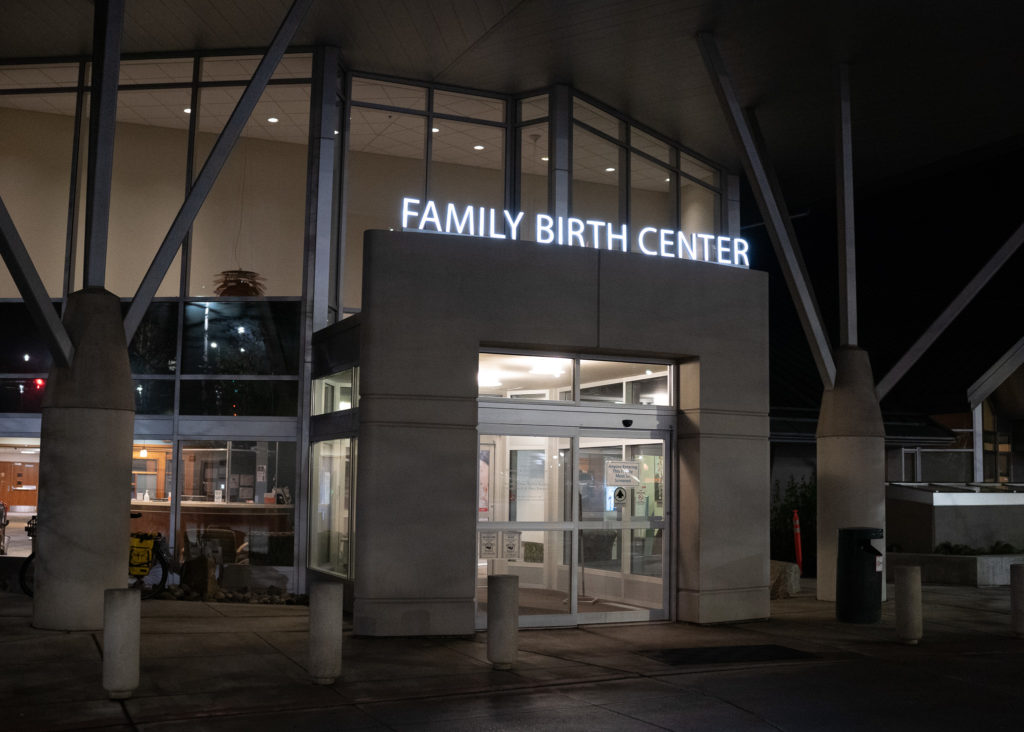 The outside of St. Michael Medical Center's Family Birth Center in Silverdale, Washington at night with the lights of Family Birth Center lit up.