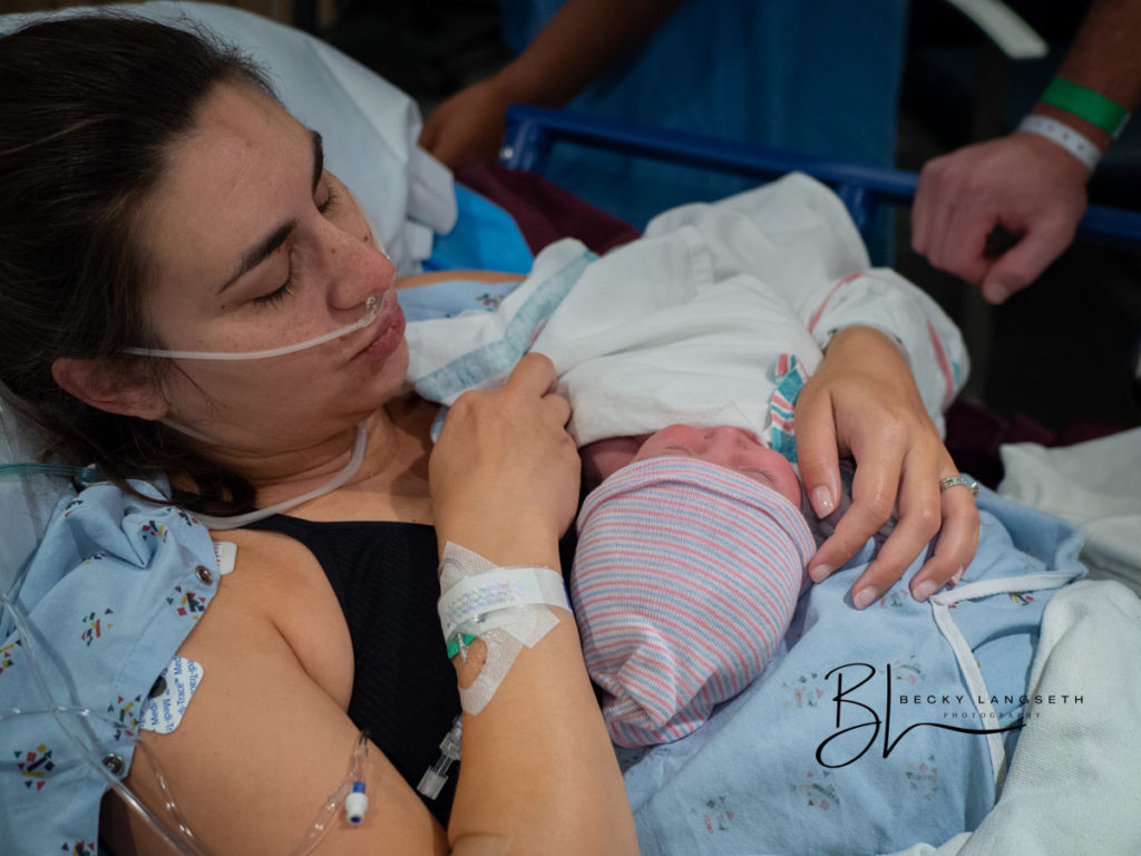 A new mother is holding her newborn for the first time at EvergreenHealth Family Maternity Center in Kirkland, WA after going through a c-section. This image was taken after 20 hours of labor, and is a good example of why birth photography is so expensive!
