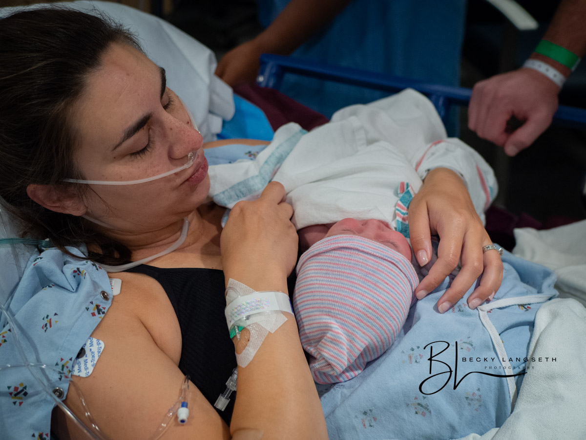 A new mother is holding her newborn for the first time at EvergreenHealth Family Maternity Center in Kirkland, WA after going through a c-section.
