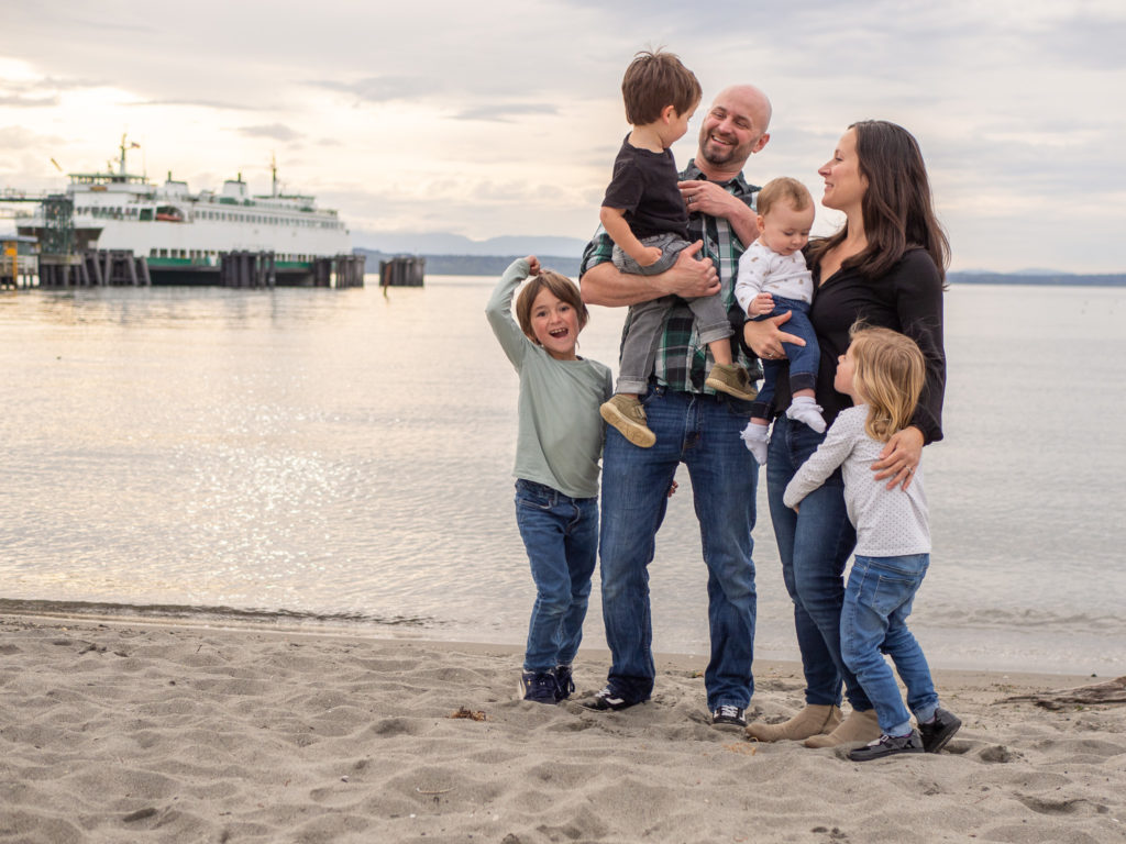 Family of five standing on Edmonds beach with the ferry in the background, by Edmonds Family Photographer, Becky Langseth.