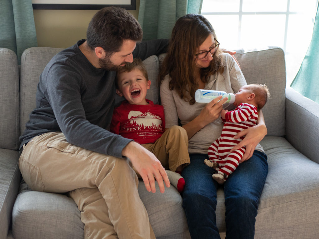 family snuggles together on the couch during their in home family photo session