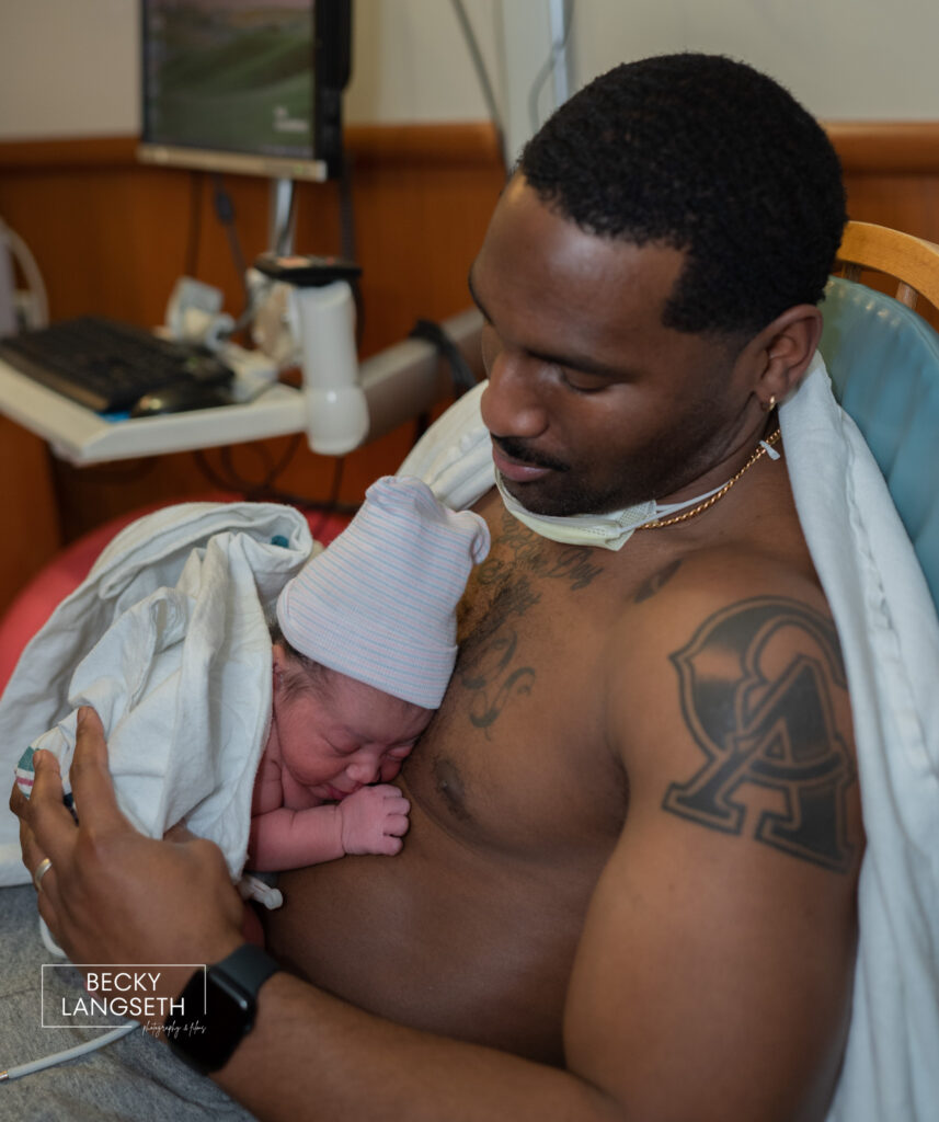A father does skin-to-skin with his newly born baby in the Family Birth Center at St. Michael Medical Center, in Silverdale, WA and is an example of birth photography.