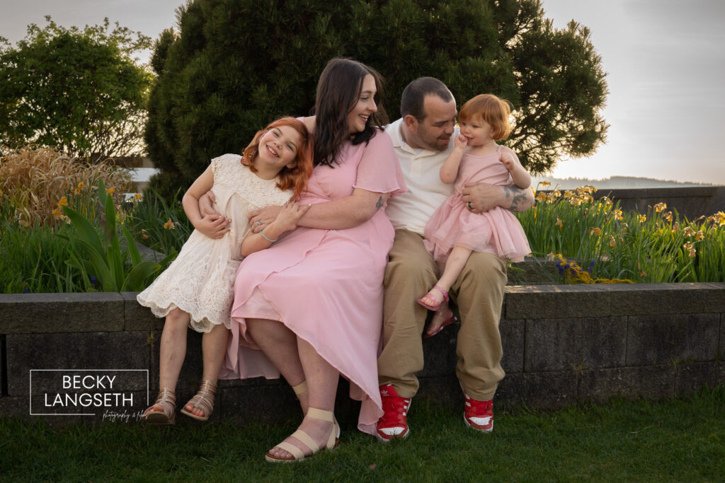 A family of four with an expecting mother pose for family photos near the beach in Mukilteo, WA.