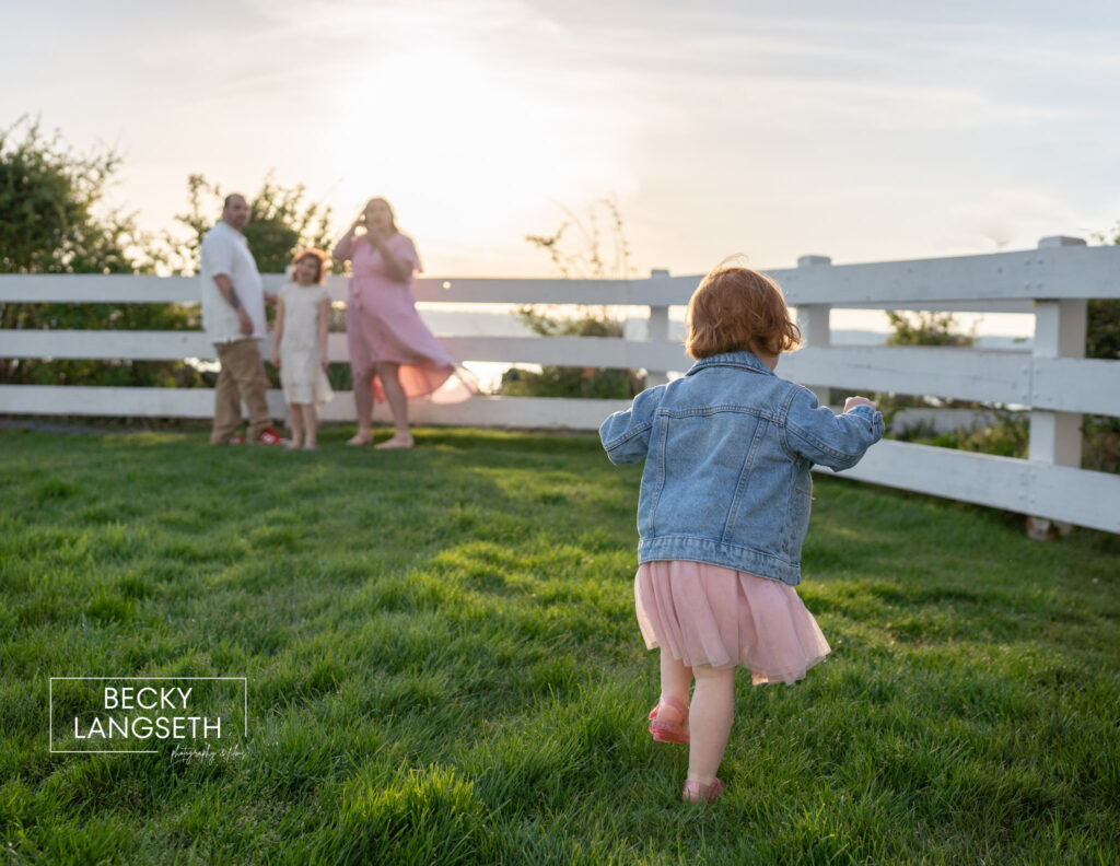A little girl runs to her family near the lighthouse at Mukilteo Lighthouse Park.