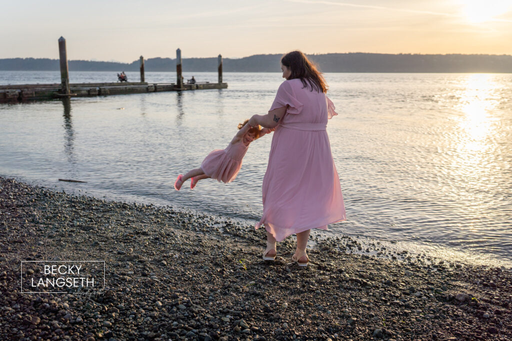 A mother swings her daughter at the beach in Mukilteo, WA taken by Seattle Family Photographer, Becky Langseth.