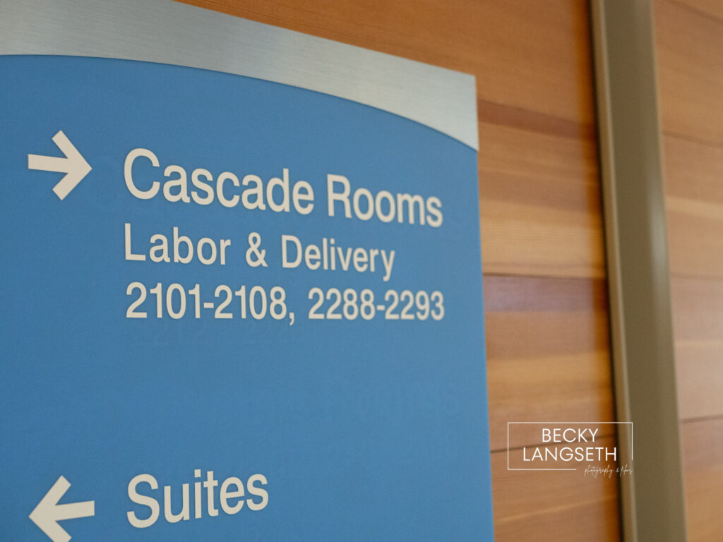 A blue sign inside of Swedish Issaquah hospital is pointing to Labor & Delivery.
