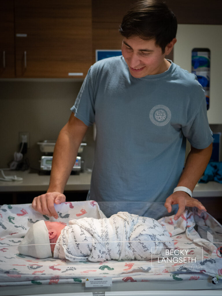 A dad looking has his newly born son in the baby warmer at Swedish Issaquah Hospital.