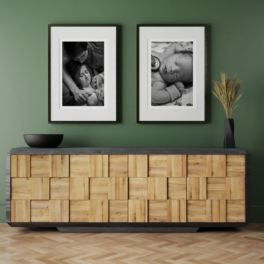 Two birth photos are displayed as wall art on a green wall above a console.