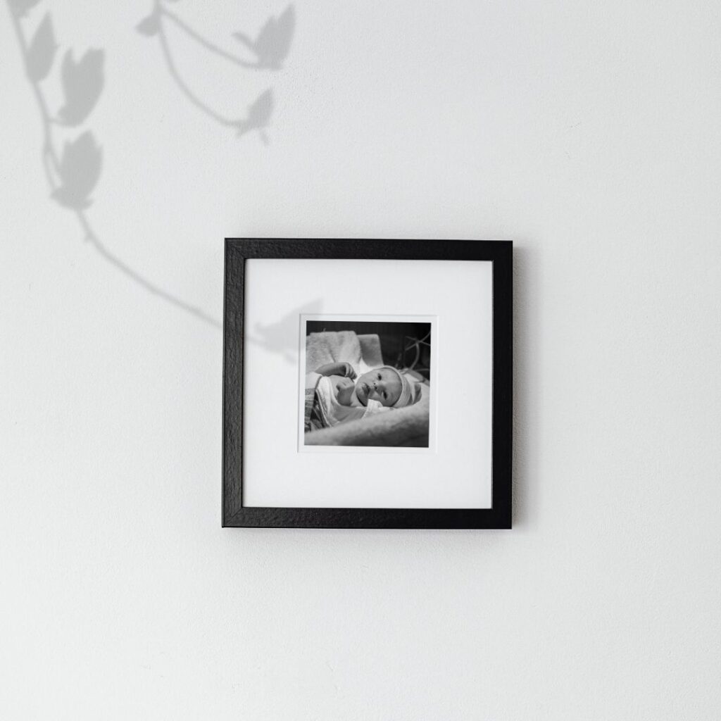 One black and white birth photo is displayed on the wall in a small black frame.