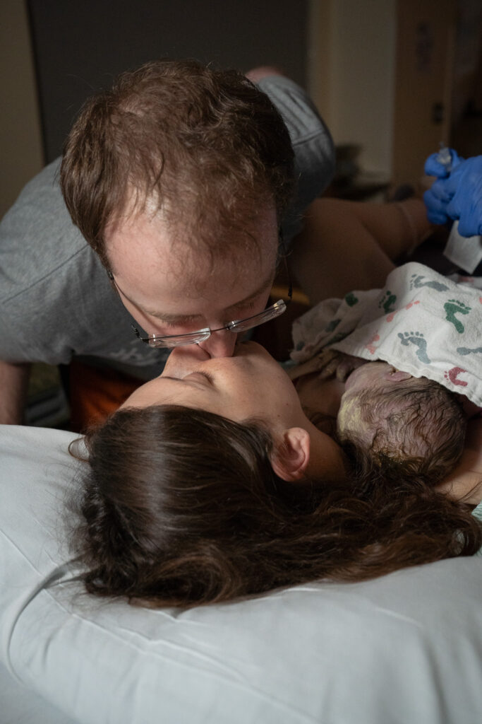 a couple kiss after delivering their baby at a Swedish Issaquah Hospital 