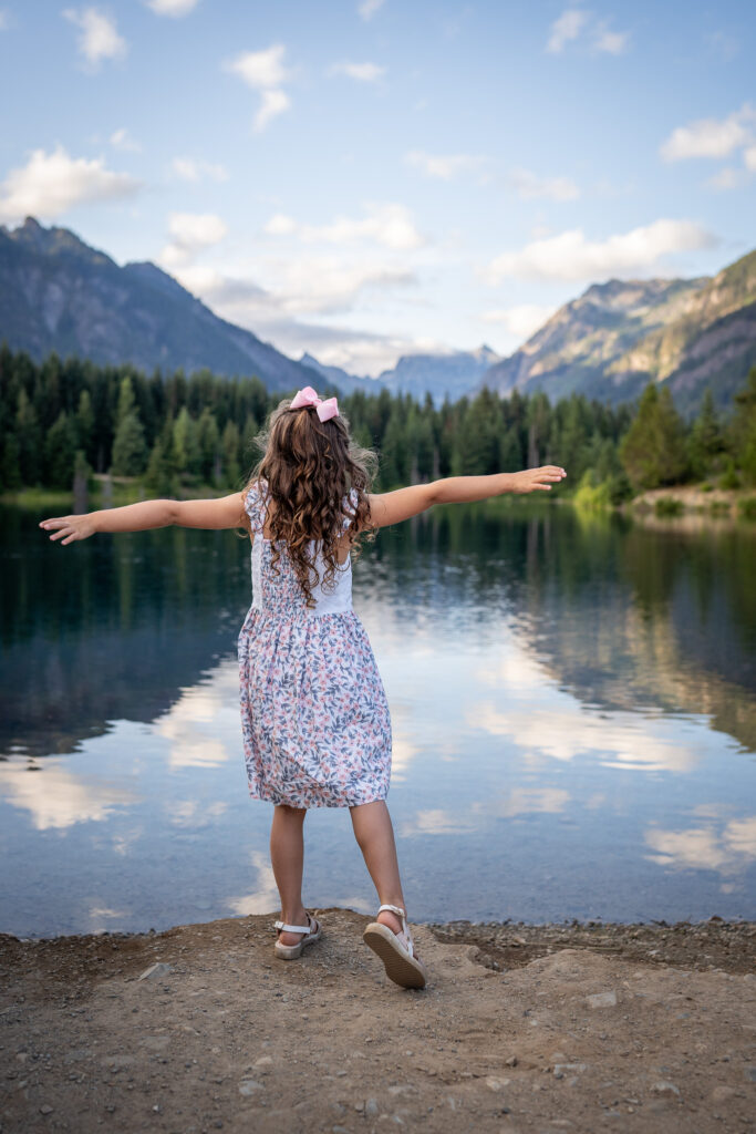 A young girl twirls at gold creek pond.