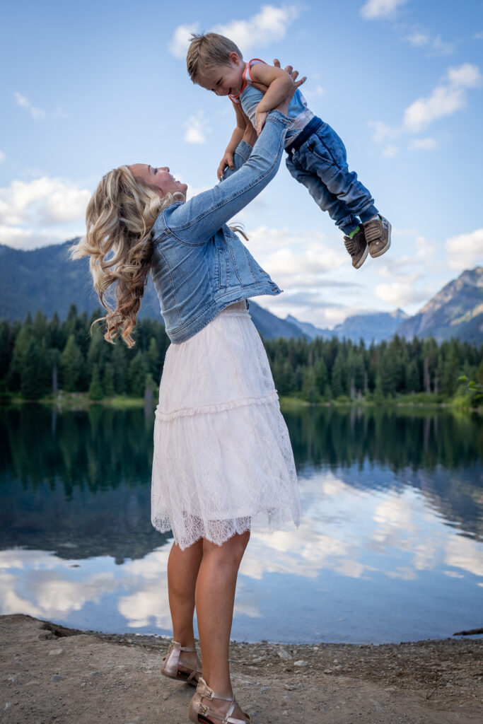 A mother tosses her small child up into the air at Gold Creek Pond