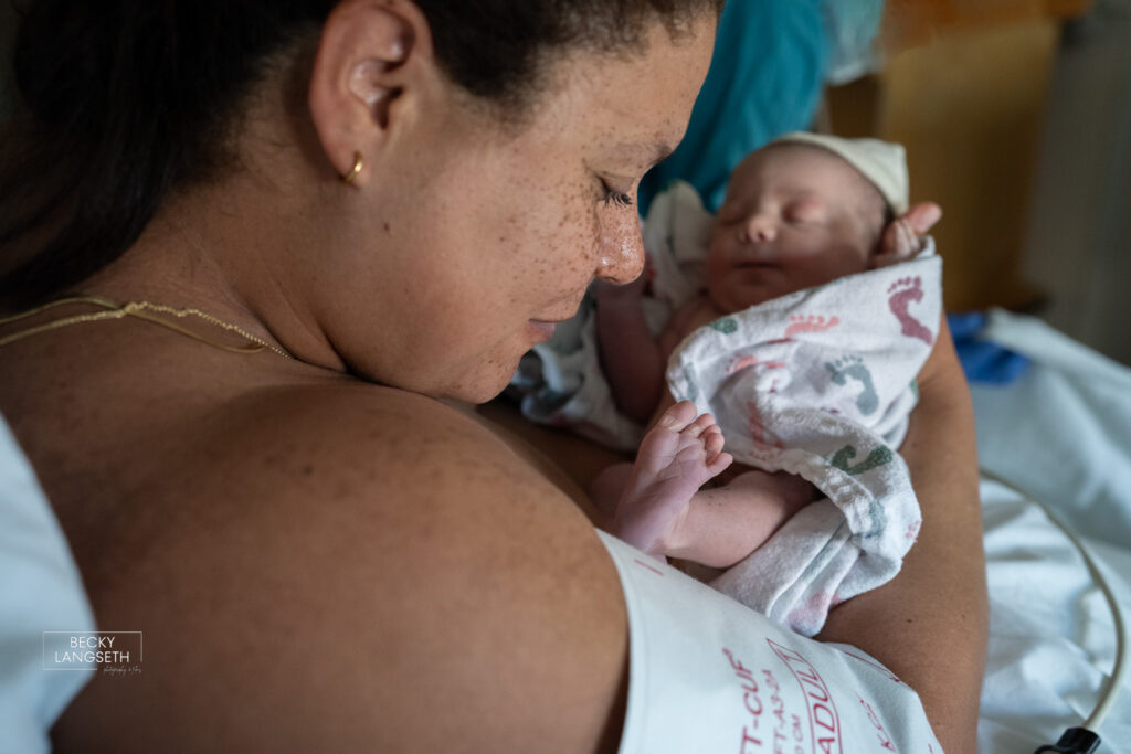 A mother inspects her new baby's tiny feet after just being born at Swedish First Hill Birth Center.