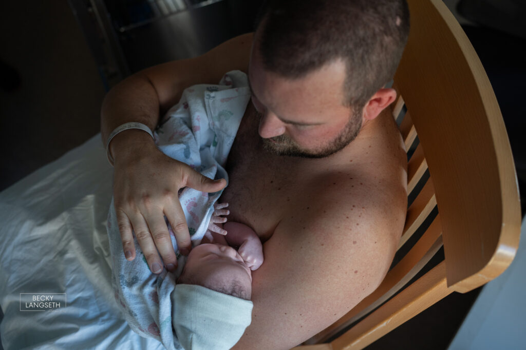Dad is holding his son skin-to-skin  shortly after being born at Swedish First Hill Birth Center