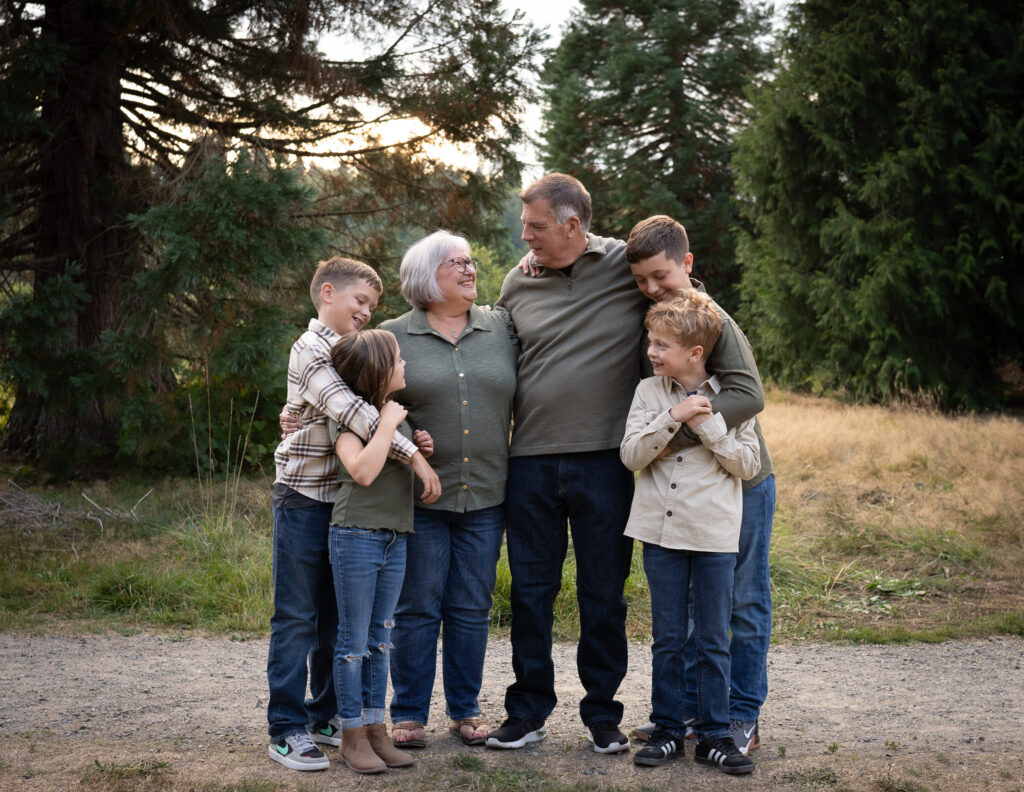 Two grandparents look at each other with their 4 grandkids surrounding them.