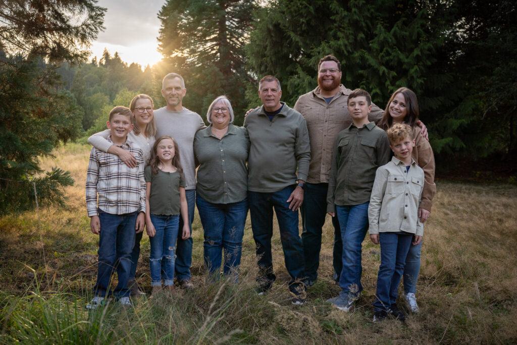 An extended family (grandparents, adult children and their families) get together for family photos at Blyth Park in Bothell, WA.