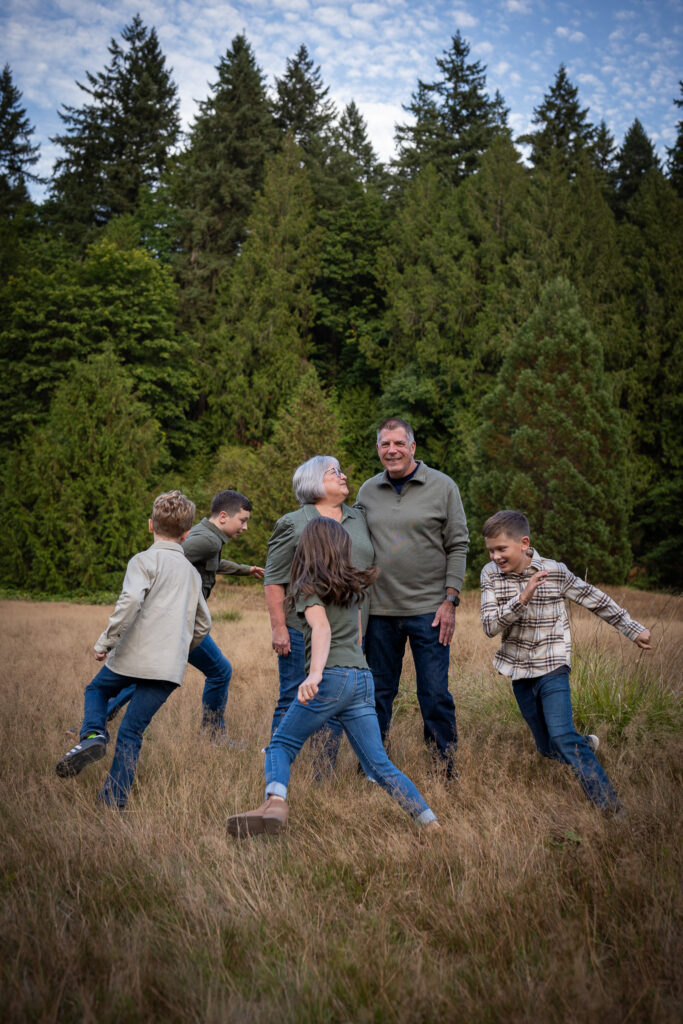 the grandkids run in a circle around the grandparents at Blyth Park in Bothell, WA.