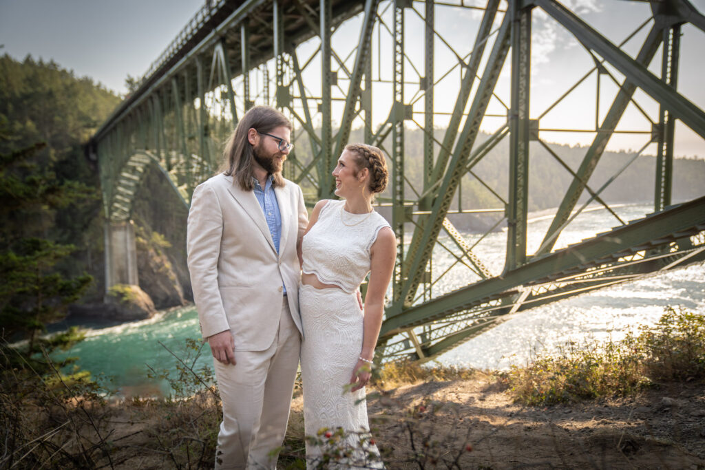 bride and groom looking at each other under the bridge at Deception Pass State Park