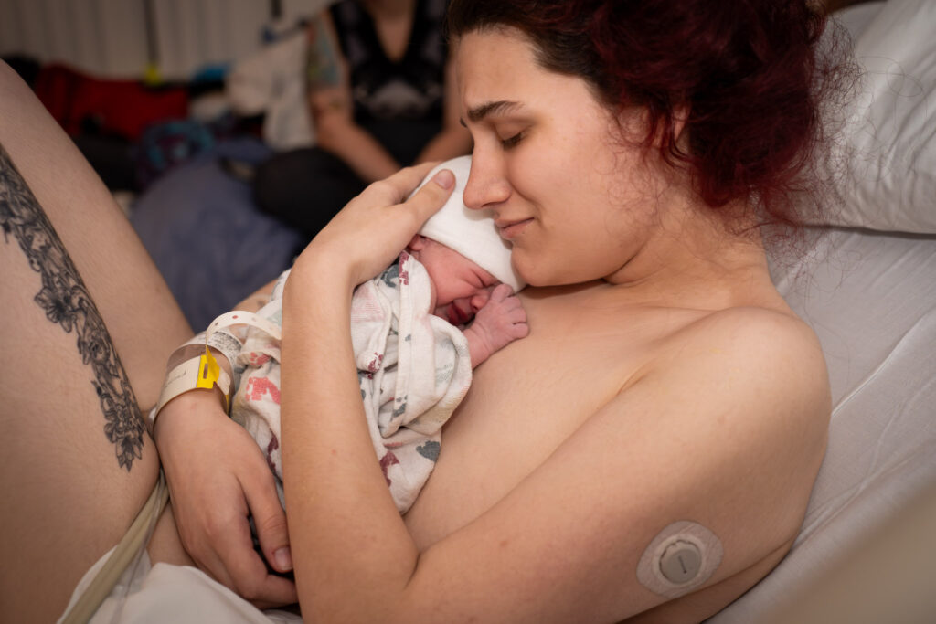 An emotional new mother cuddles her baby for the first time after giving birth at Providence Everett