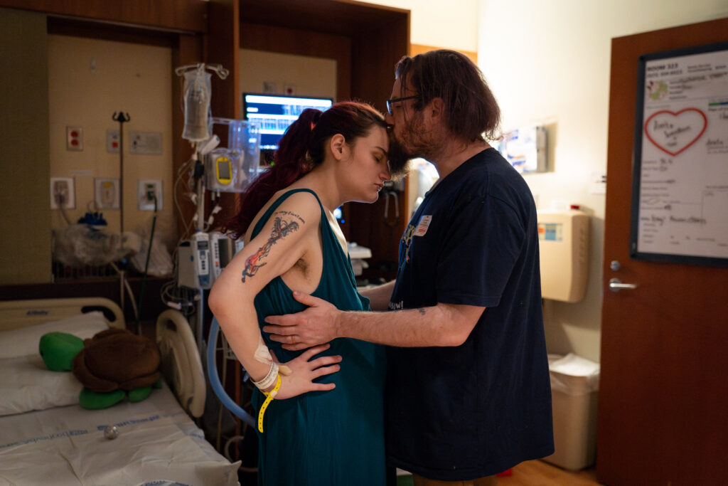 a soon-to-be new dad helps his pregnant partner cope by slow dancing in the hospital room as she endures a contraction