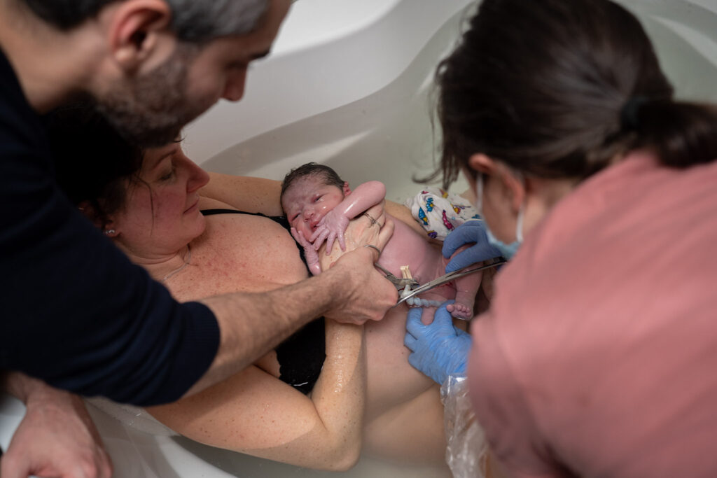 A father cuts the umbilical cord of his recently born baby