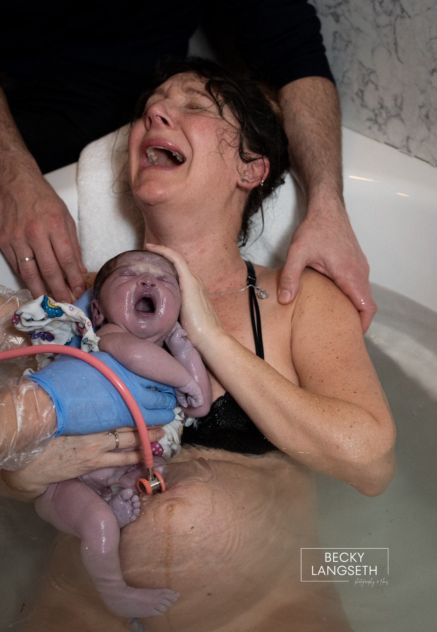 A mother and baby cry as the mother holds her baby for the first time after giving birth in a tub at the Puget Sound Birth Center.
