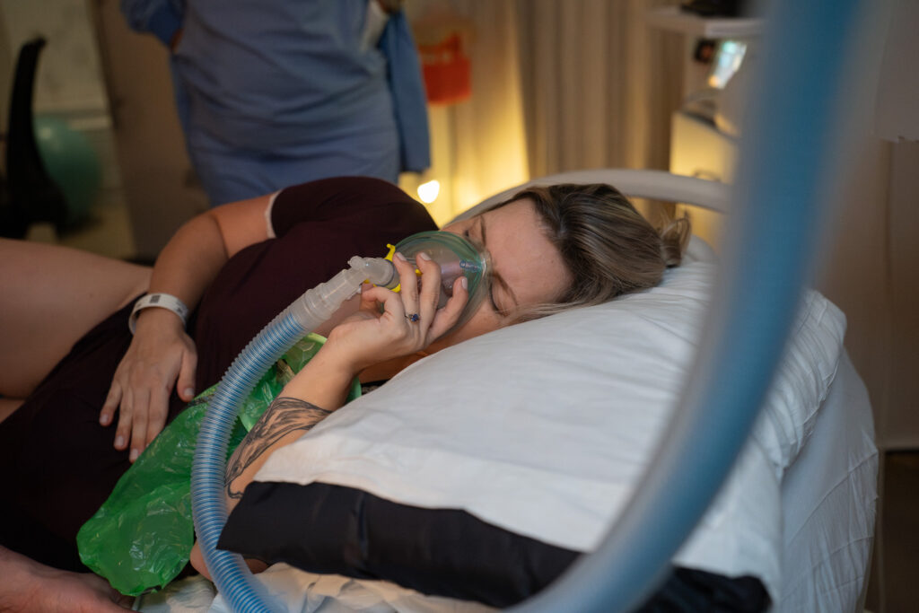 A pregnant mother using nitrous oxide as an aide as she labors at UW Northwest Childbirth Center