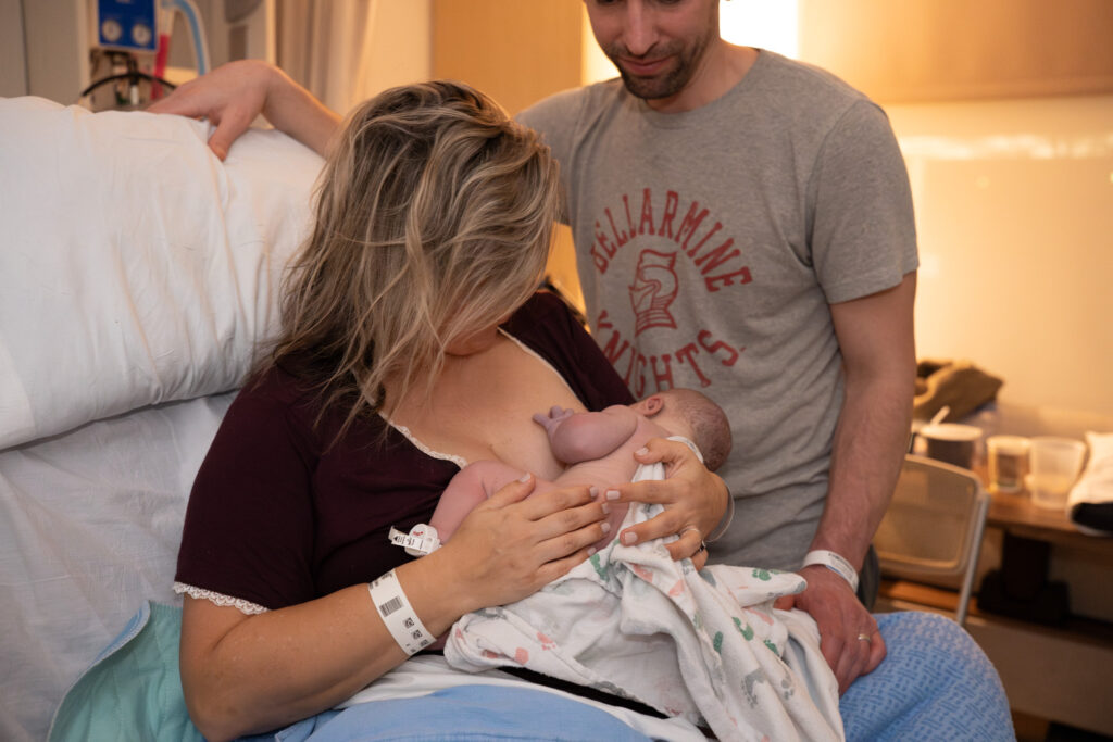 A mama is breastfeeding her baby for the first time after giving birth at a hospital.