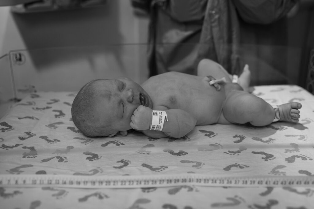 newborn infant laying in a babywarmer