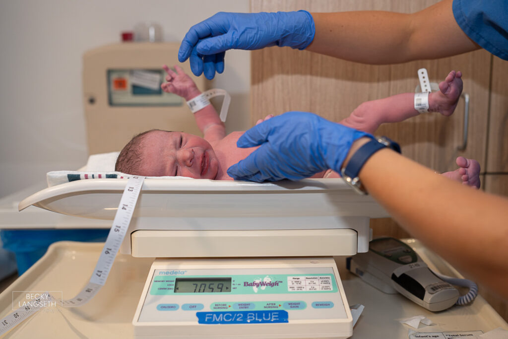 a new baby is being weighed on a scale at EvergreenHealth Family Maternity Center