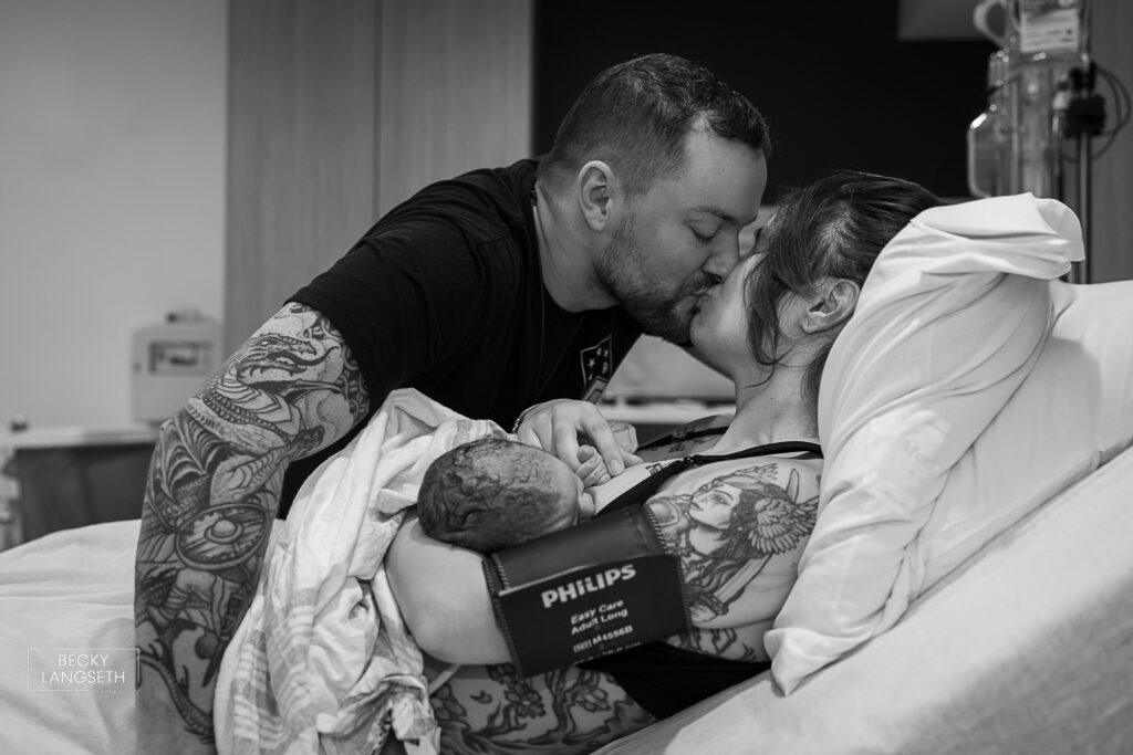 husband and wife kiss after their baby was born at Evergreen Hospital in Kirkland, WA