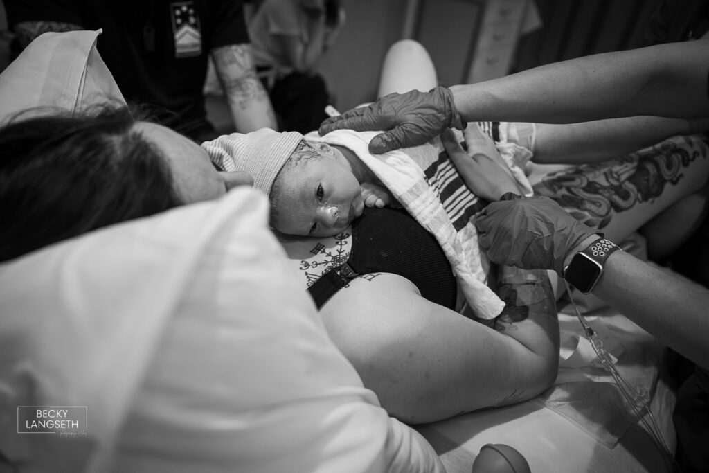 a freshly born baby is on the chest of his mother with his eyes wide open at Evergreen Hospital in Kirkland, WA