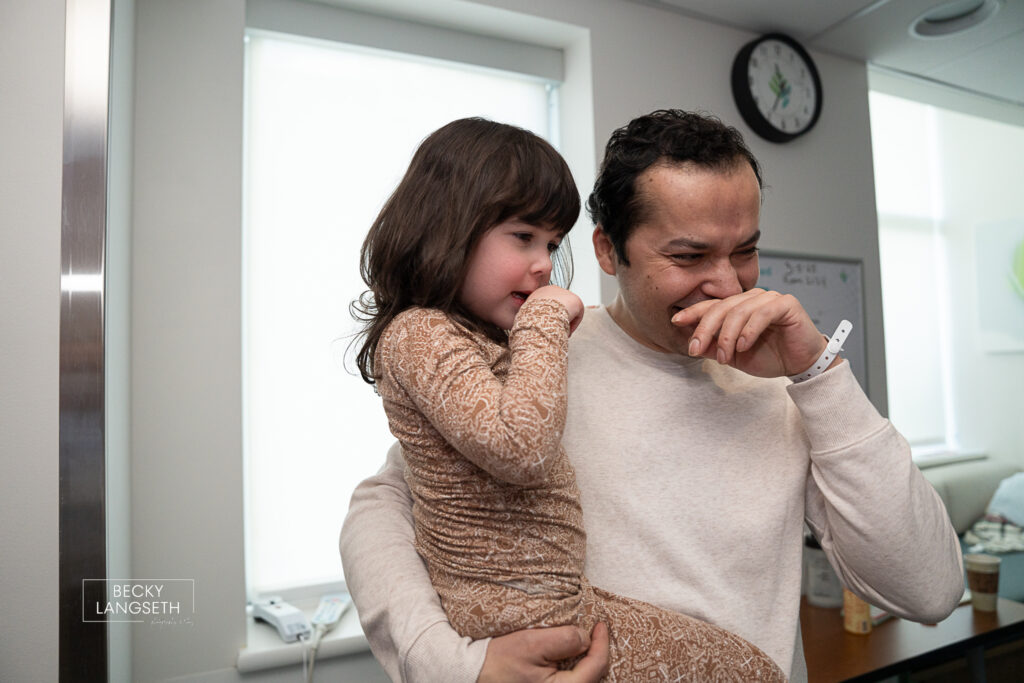A father wipes away tears from crying out of the joy of witnessing his wife give birth