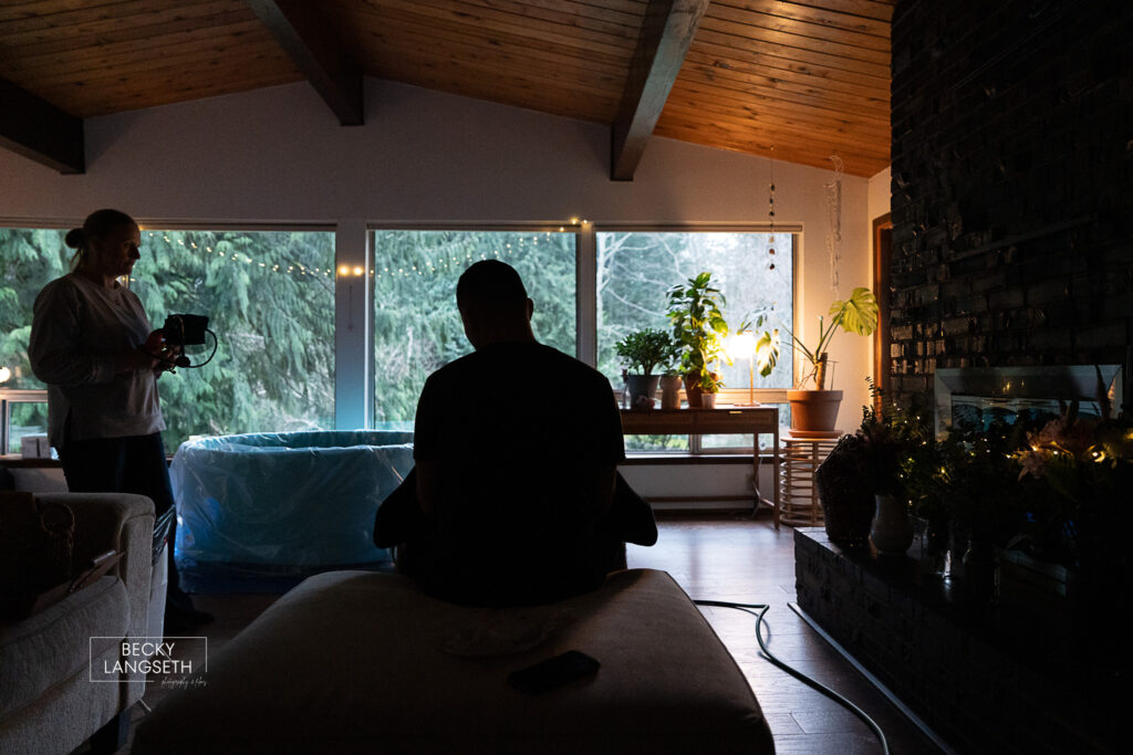 silhouette of a husband supporting his pregnant wife in their living room