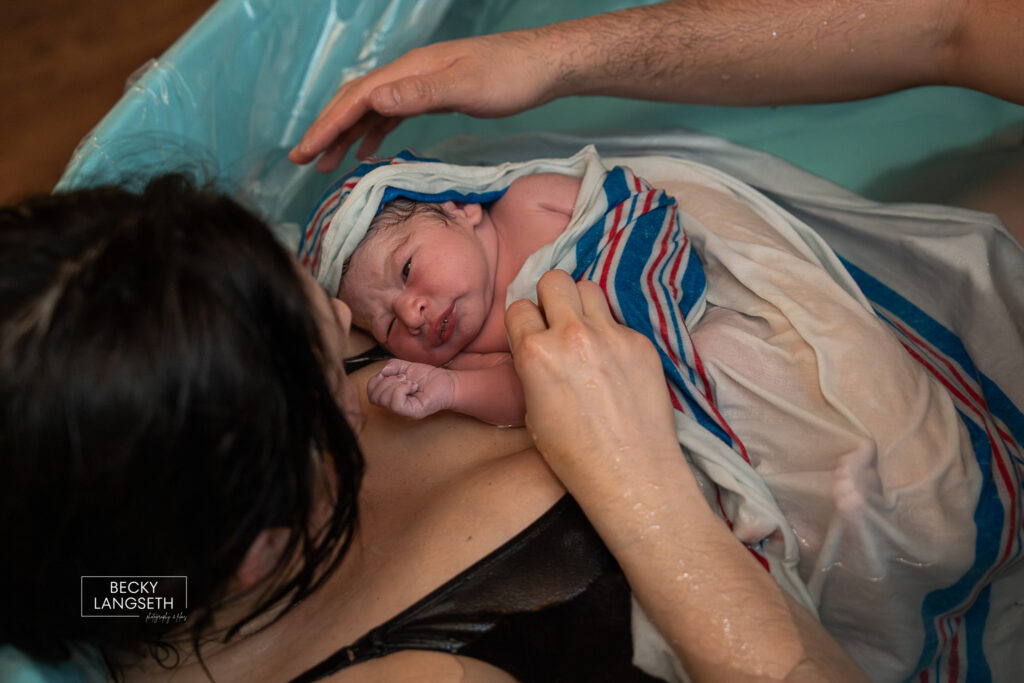 close up of mom holding her new baby born at home