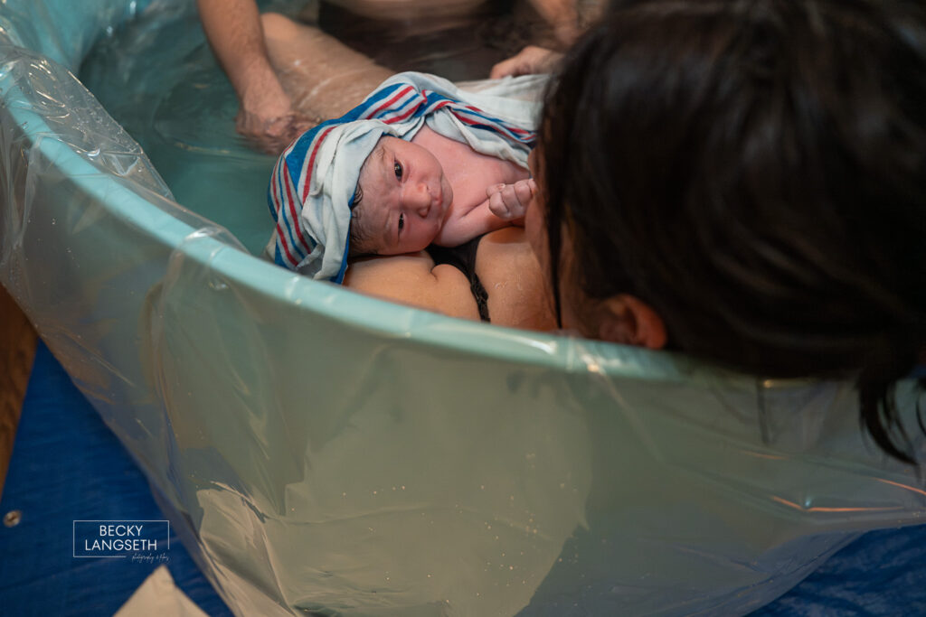 new baby with wide eyes recently born in a waterbirth at home in Sammamish, WA