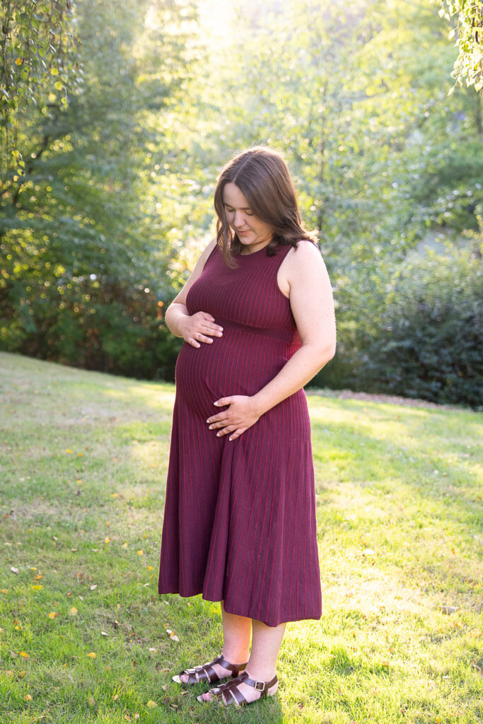 a woman is looking down at her pregnant belly